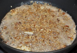 Убрать огонь до среднего, разогреть в другой сковороде растительное масло, добавить сливочного. Минуту обжаривать очищенный, раздавленный чеснок. Всыпать предварительно раздробленные орехи, помешивать, жарить 2-2,5 минуты.