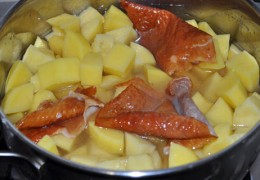 Картошку поставить варить, положить в кастрюлю и срезанную кожу – она придаст картошке аромат копчености. Тушить накрытой, на небольшом огне.