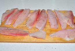 Рыбное филе промыть, обсушить разовыми полотенцами. Нарезать на куски, которые можно плотно уложить на дне сковороды. С обеих сторон приправить перцем и солью. Ладонью похлопать, вбивая приправы в рыбу.