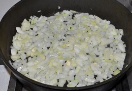 Пока овощи запекаются, на средний огонь поставить для разогрева сковороду с маслом. Нашинковать лук, ломтиками нарезать чеснок. Засыпать в сковороду, пассеровать, помешивая, 5-6 минут.