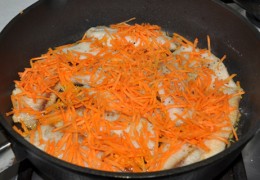 Заранее натертой морковью посыпать рыбу в сковороде.