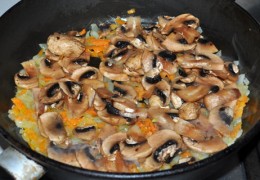 А в сковороду пора добавить грибы, нарезанные довольно толстыми ломтиками. Готовить еще 4 минуты.