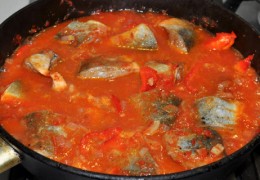 Добавить нарезанный полосками остаток сладкого перца, куски рыбы, перемешать, накрыть и тушить рыбу в соусе, убрав огонь до небольшого, 18-20 минут – до готовности.