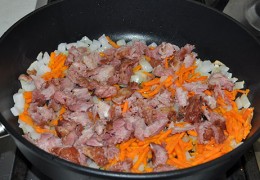 Вместе с морковью добавить копчености к луку и обжаривать 3-4 минуты.  